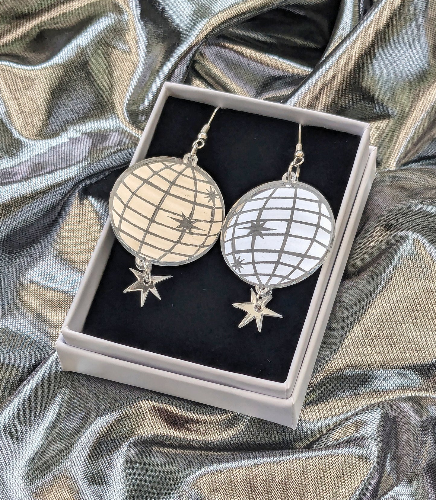 Acrylic mirror effect disco ball earrings boxed on a silver fabric background