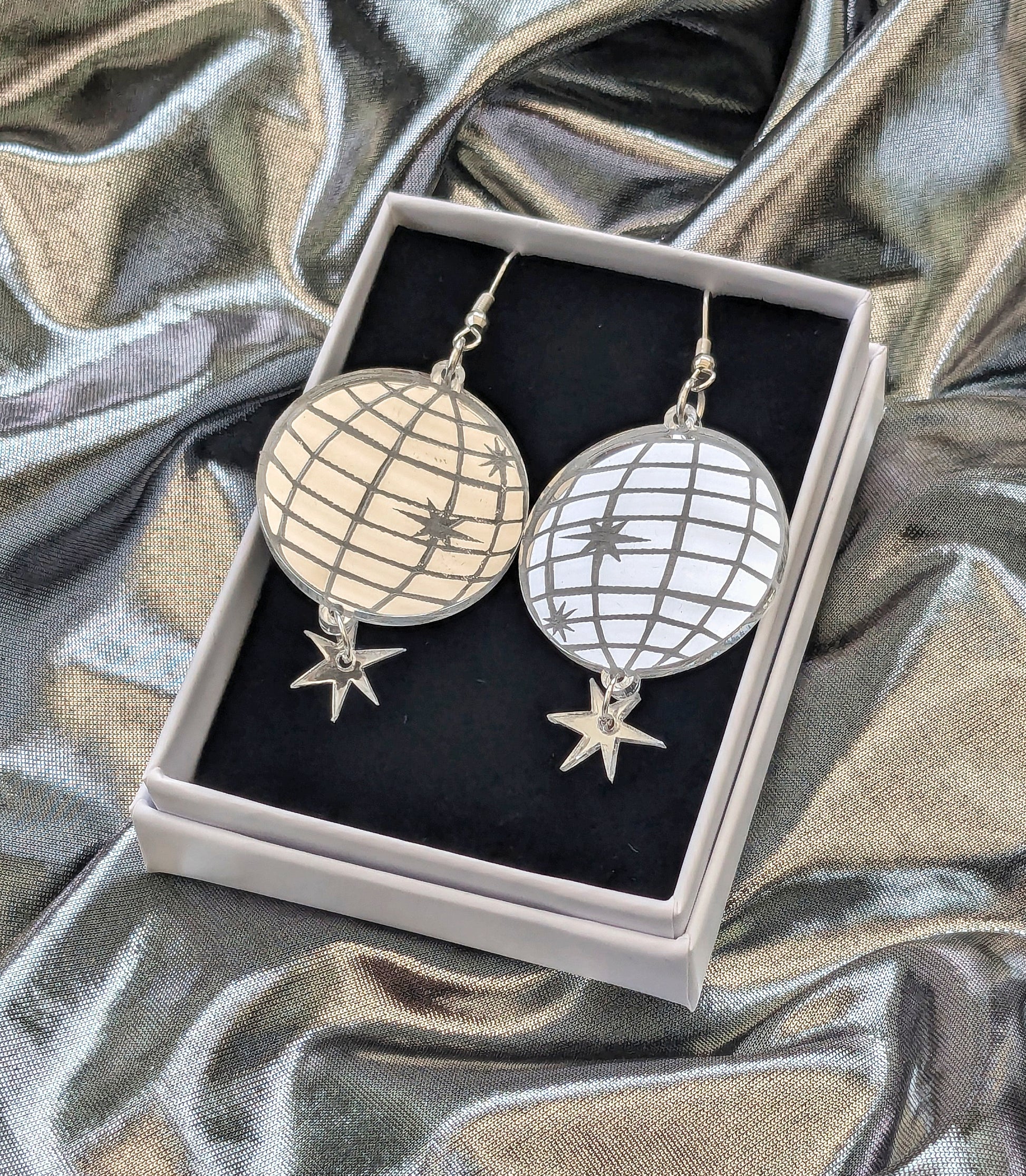 Acrylic mirror effect disco ball earrings boxed on a silver fabric background