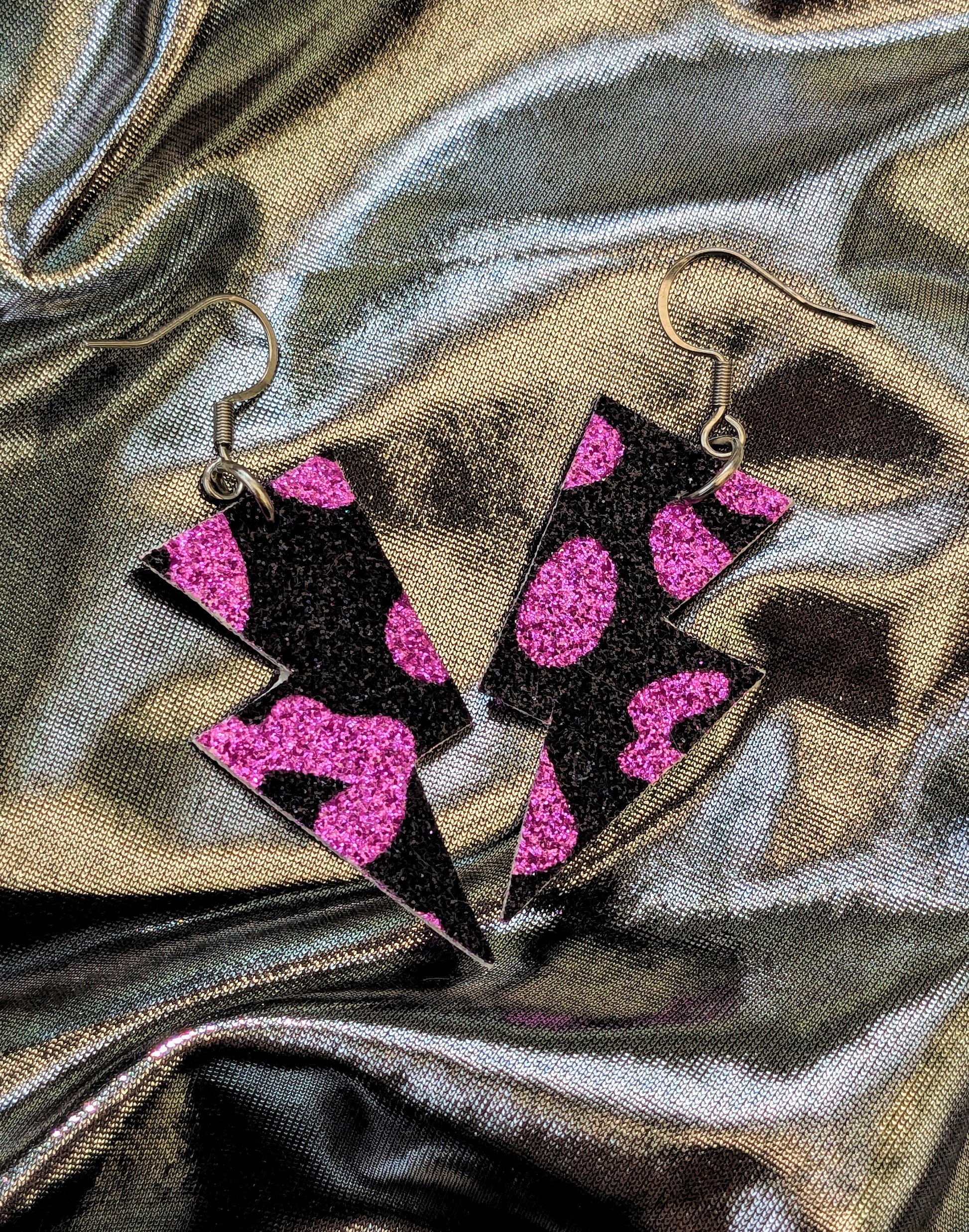 small leopard print lightning bolt earrings in pink and black glitter fabric