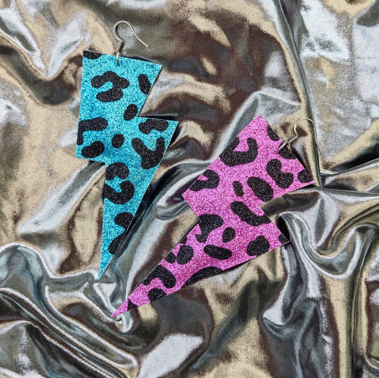 Large leopard print lightning bolt earrings in turquoise, pink and black glitter