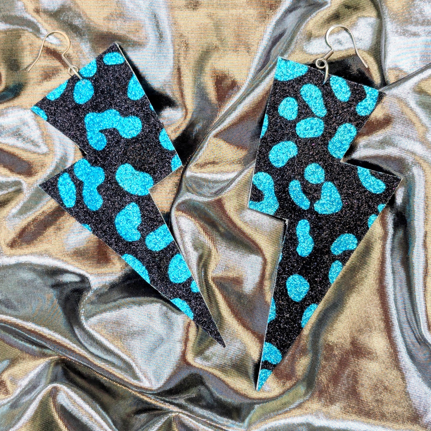 Large leopard print lightning bolt earrings in turquoise and black glitter