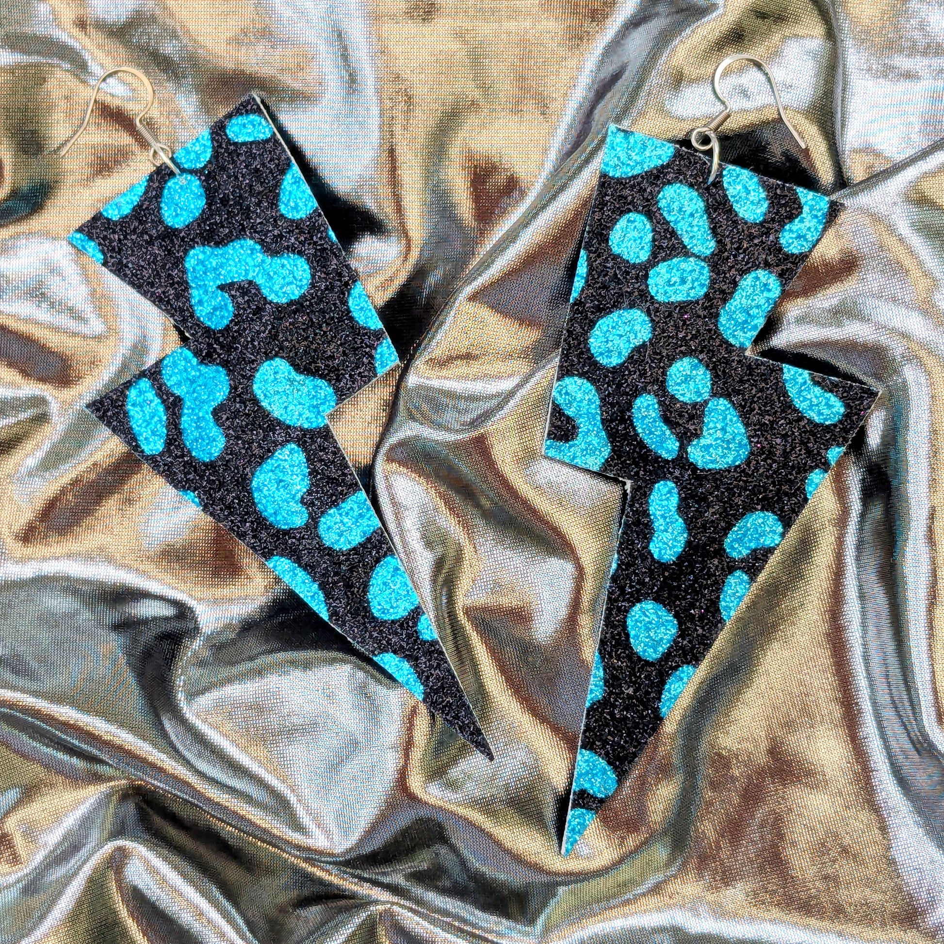 Large leopard print lightning bolt earrings in turquoise and black glitter