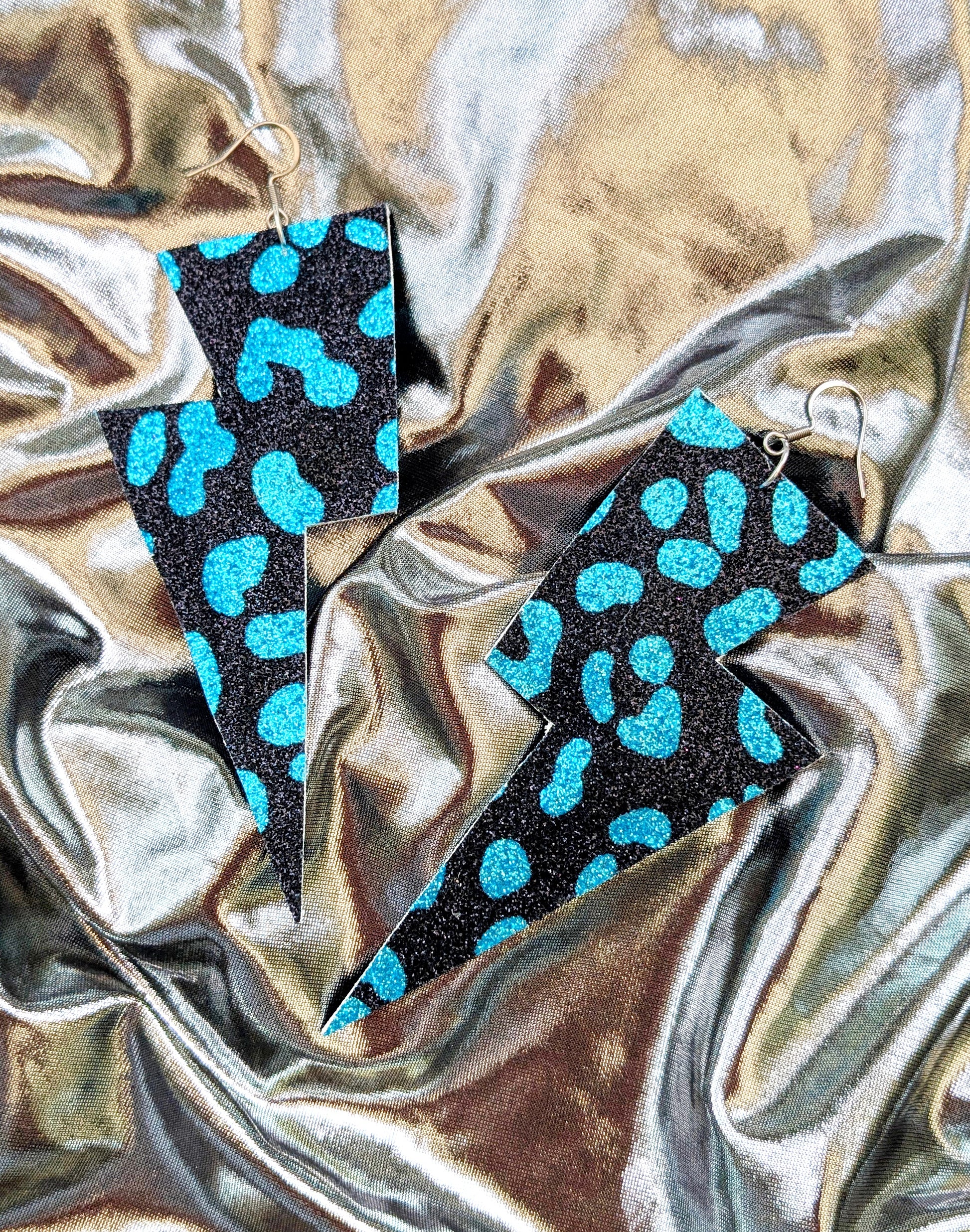 Large leopard print lightning bolt earrings in turquoise and black glitter