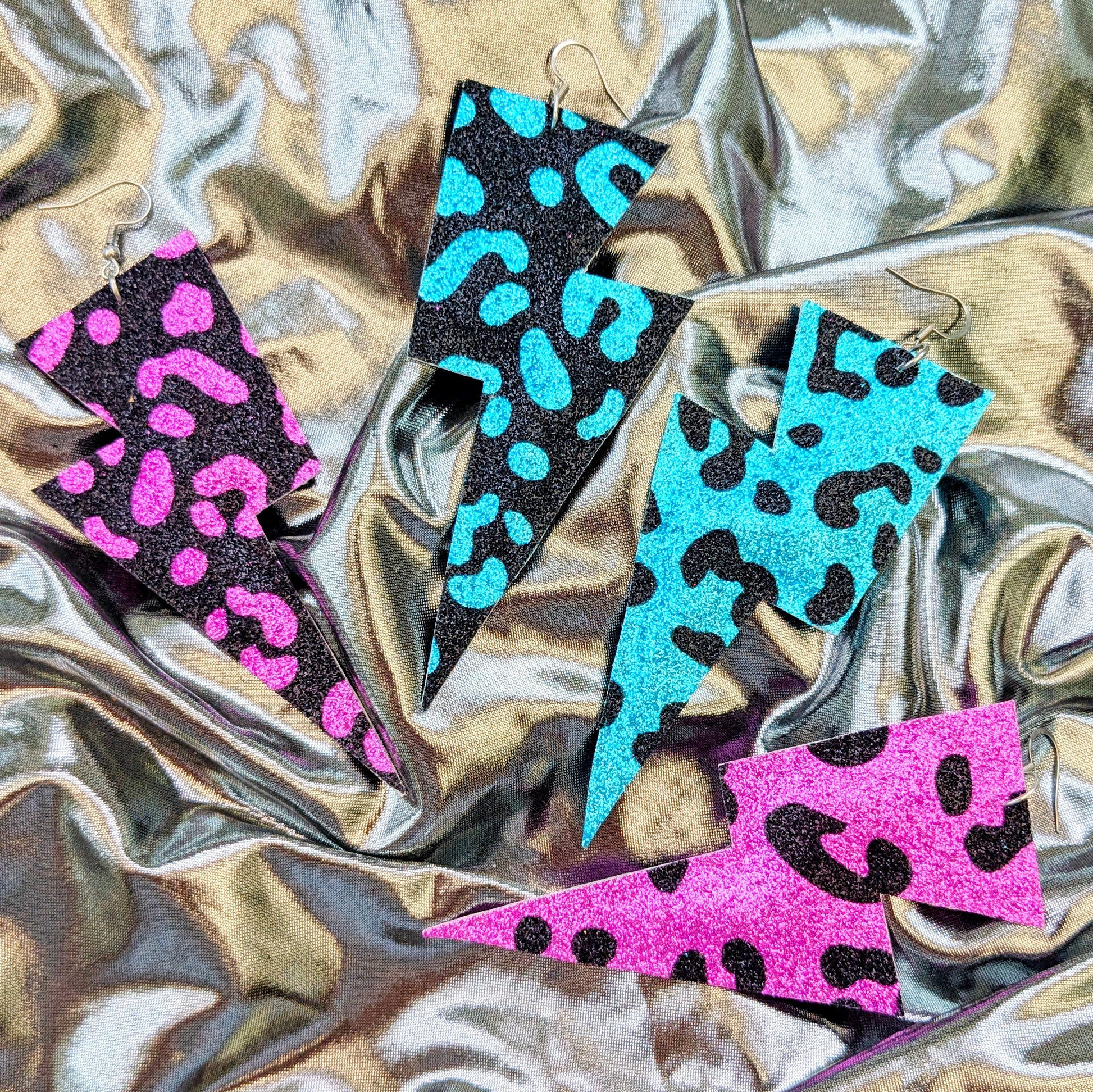 Large leopard print lightning bolt earrings in turquoise, pink and black glitter