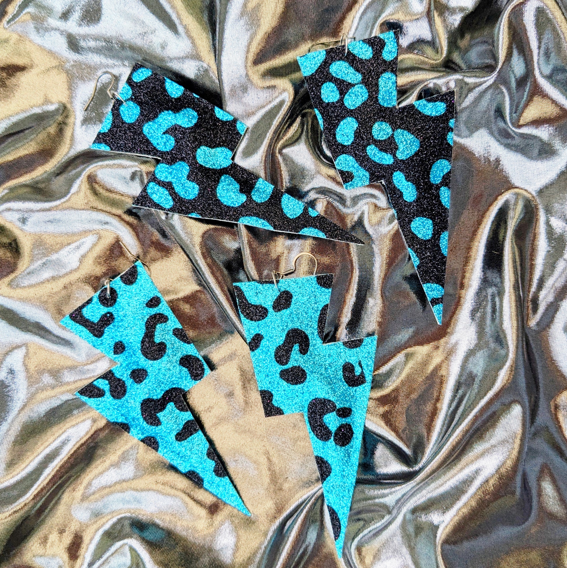 Large leopard print lightning bolt earrings in turquoise and black glitter