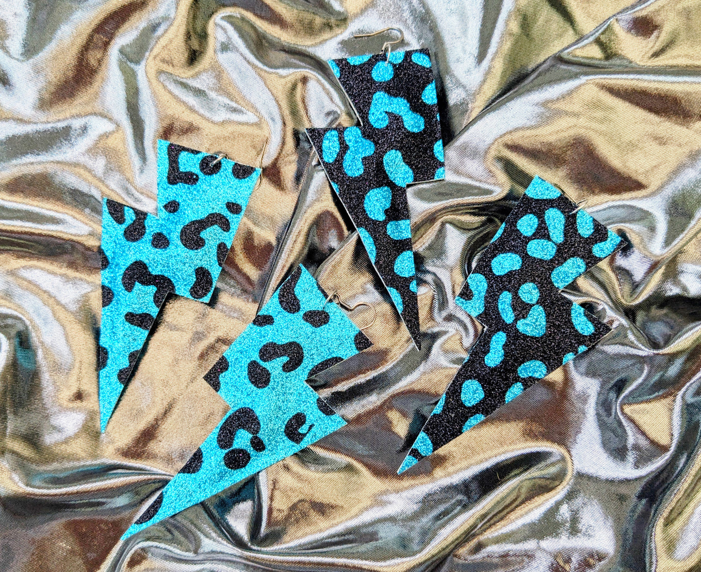 Large leopard print lightning bolt earrings in turquoise and black glitter