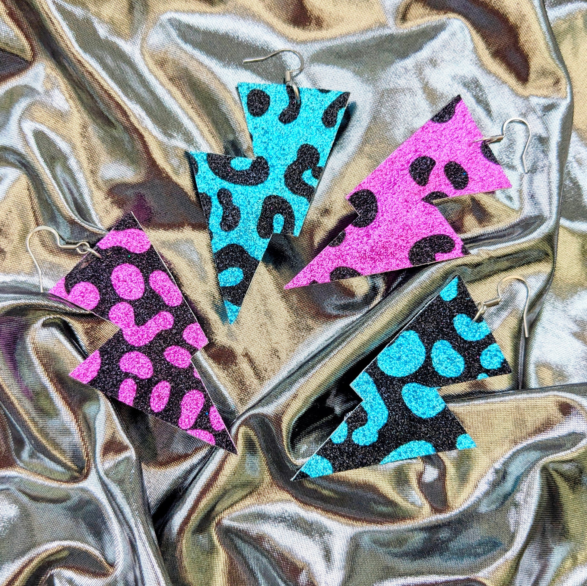 Medium leopard print lightning bolt earrings in turquoise, pink and black glitter