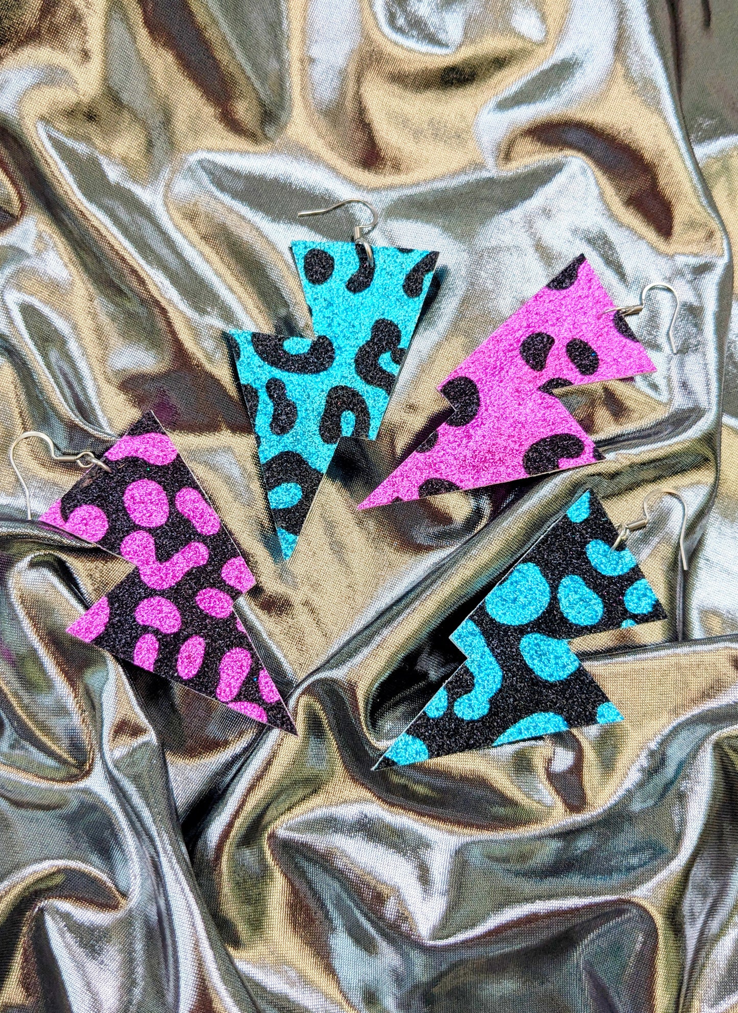 Medium leopard print lightning bolt earrings in turquoise, pink and black glitter