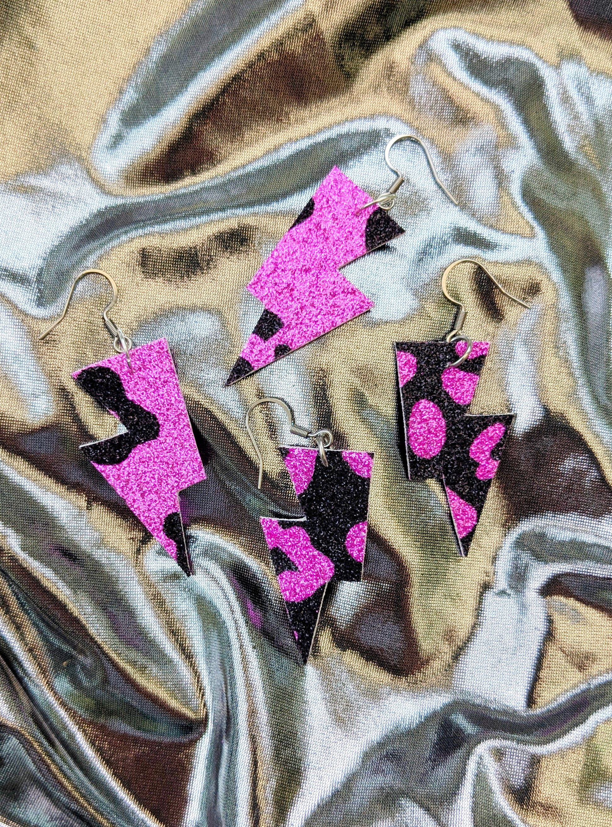 small leopard print lightning bolt earrings in pink and black glitter fabric