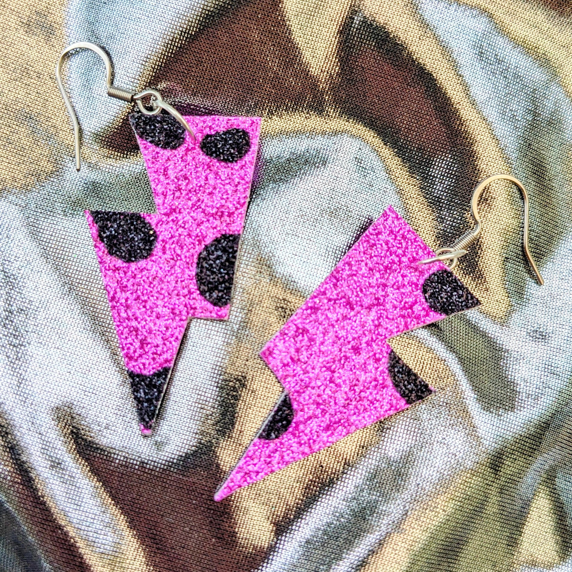 small leopard print lightning bolt earrings in pink and black glitter fabric