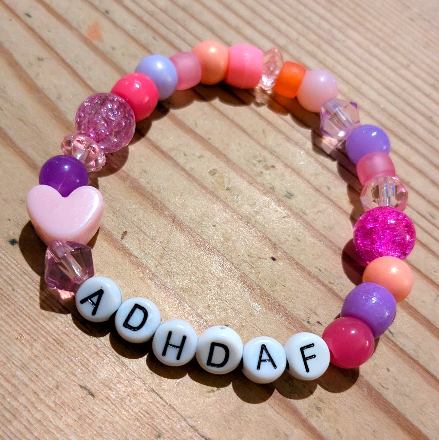 Friendship Bracelet in pink and purple beads with bead letters spelling ADHDAF