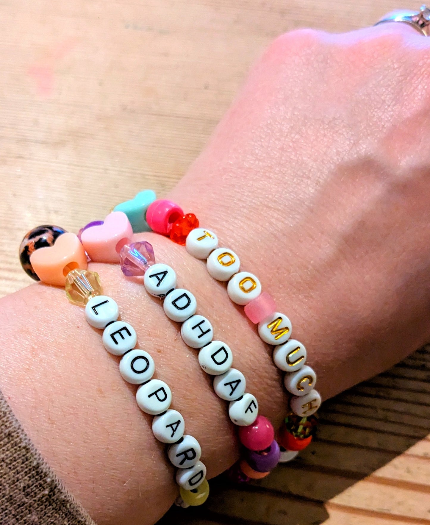 Hand modelling 3 friendship bracelets 'Too Much', 'ADHDAF' and 'Leopard Print Army'