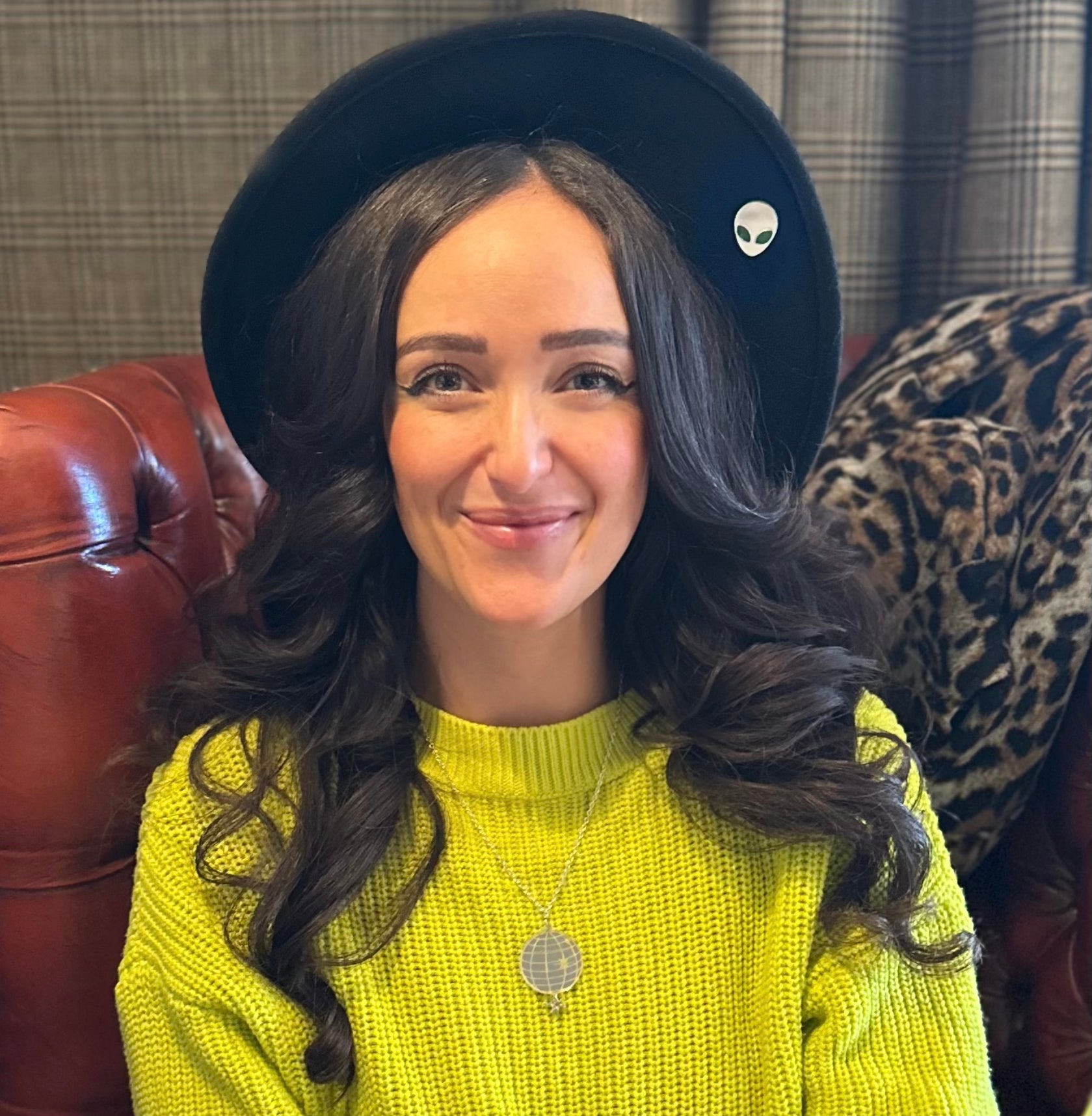 Laura wears silver disco ball necklace against neon green jumper