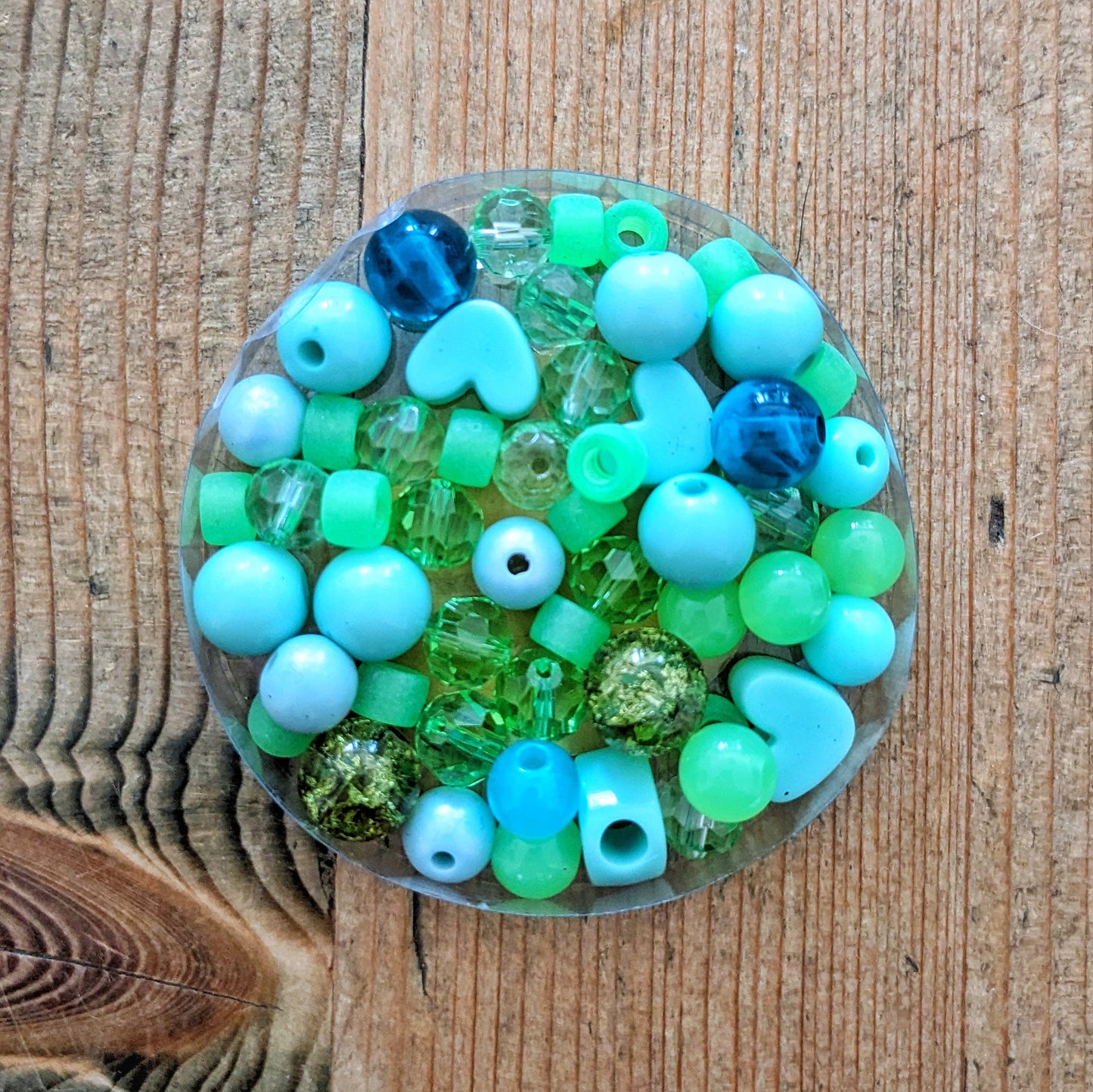 Variety of glass and acrylic beads in greens